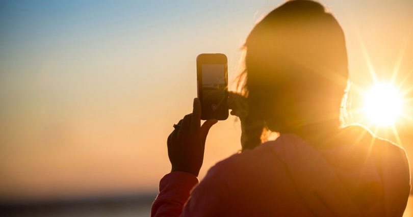 woman texting during sunset