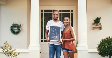 new home owners holding sign