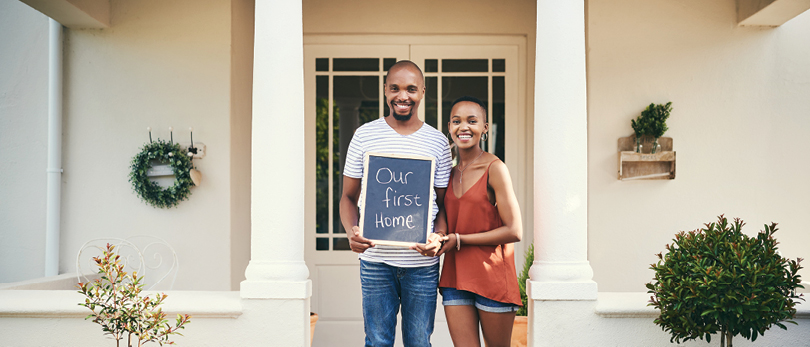 new home owners holding sign