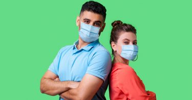 man and woman back to back with masks on for coronavirus protection