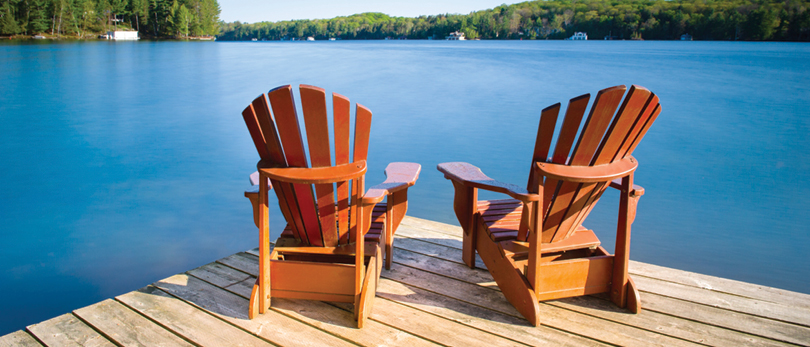 two wooden chairs on a dock