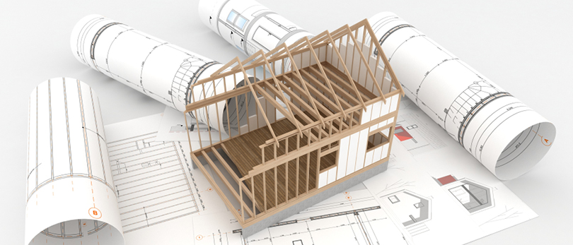 frame of house with blueprints