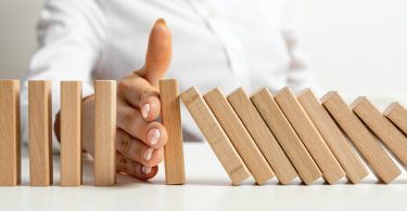 hand stopping wood blocks from falling