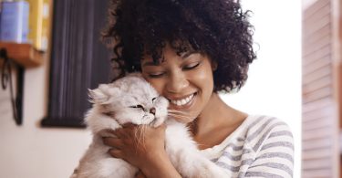 woman cuddling cat