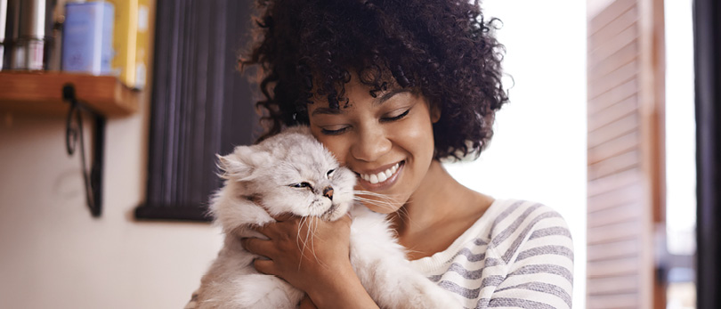 woman cuddling cat