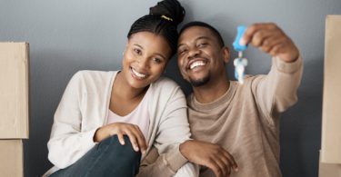 Black couple holding up keys