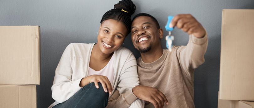 Black couple holding up keys