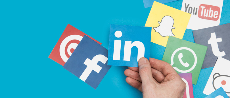 social media icons with LinkedIn held by hand