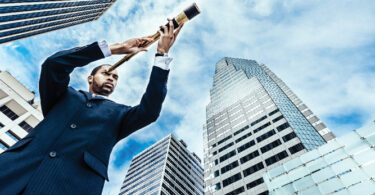 man in city using scope to look outward