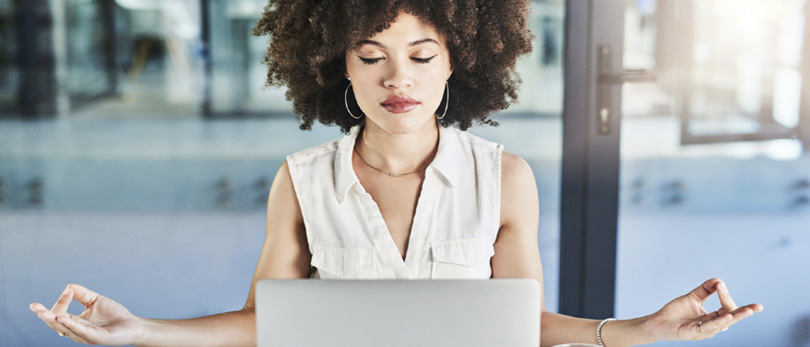 woman practicing mindfulness in front of computer