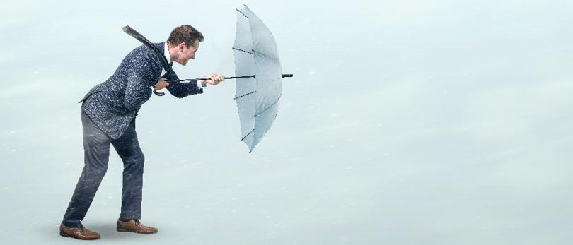 man fighting wind with umbrella