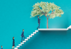 People walking up a white staircase with a tree on a landing in the middle